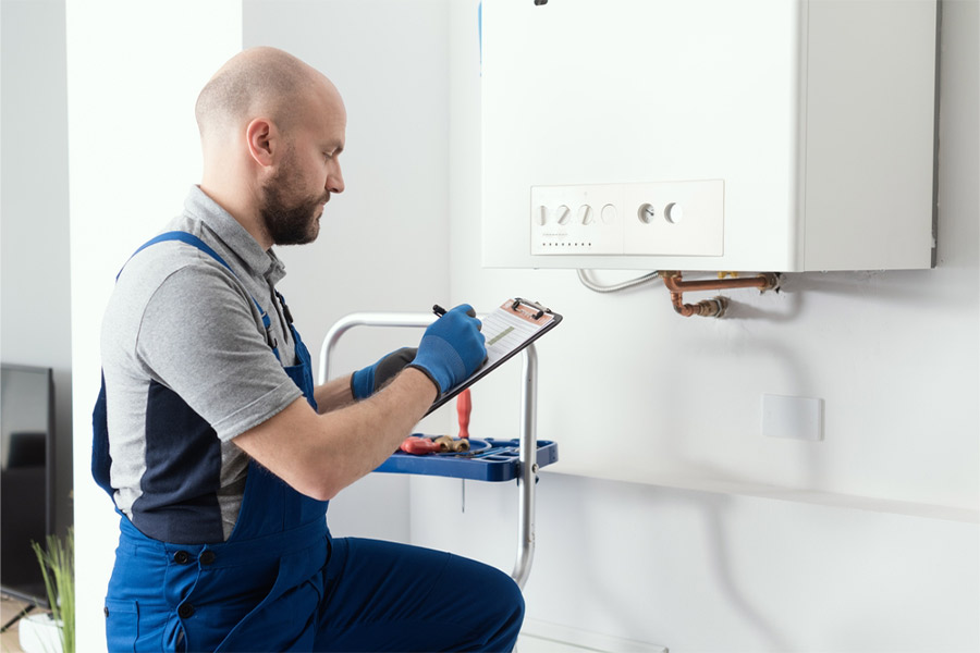 Gas-engineer-writing-a-gas-safety-certificate-and-boiler-records-after-servicing
